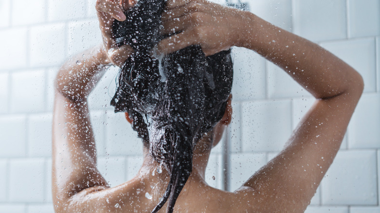 Woman washing hair in shower.