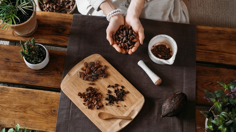 Woman holds handful of cacao beans