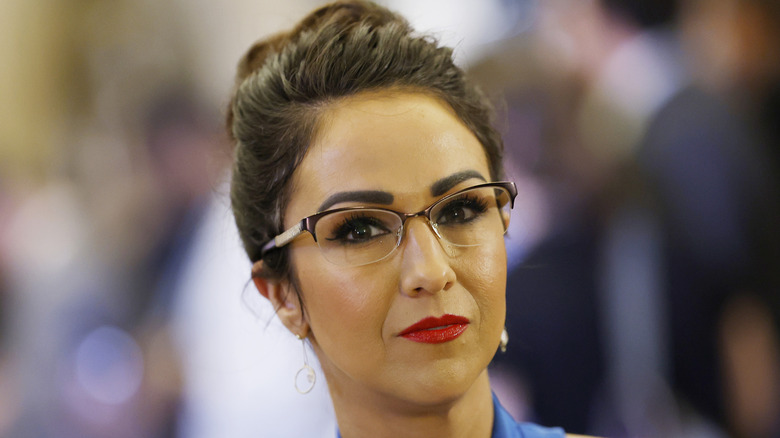 Lauren Boebert with red lipstick and glasses wearing an updo