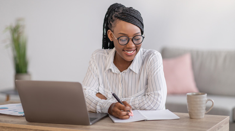 Woman takes notes from webinar.
