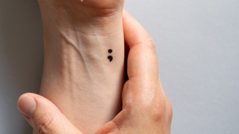 Semicolon tattoo on a person's wrist