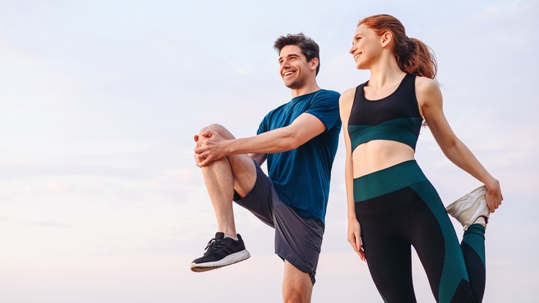 Man and woman stretchiing on beach