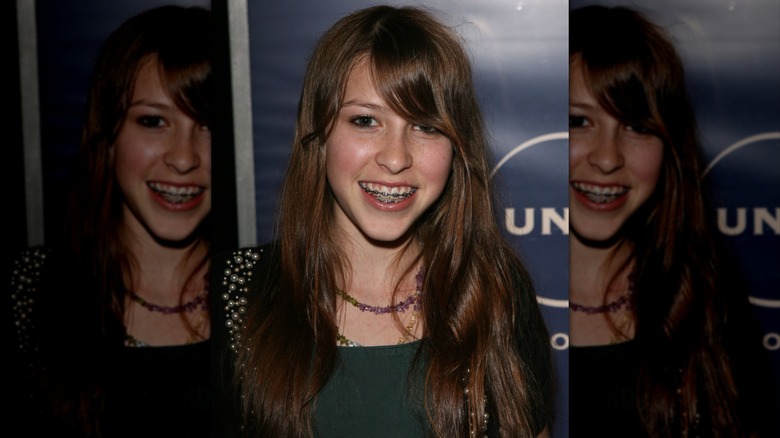 Young Eden Sher is photographed with braces and side bangs at a television press event