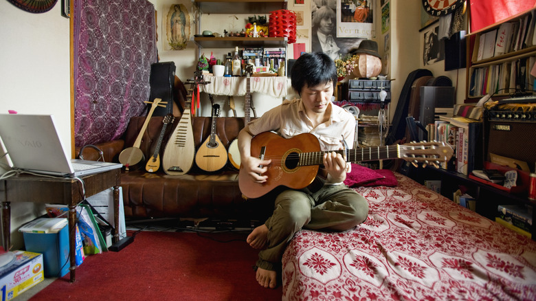 Man sitting, playing guitar