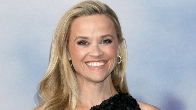 Reese Witherspoon smiling in a black dress