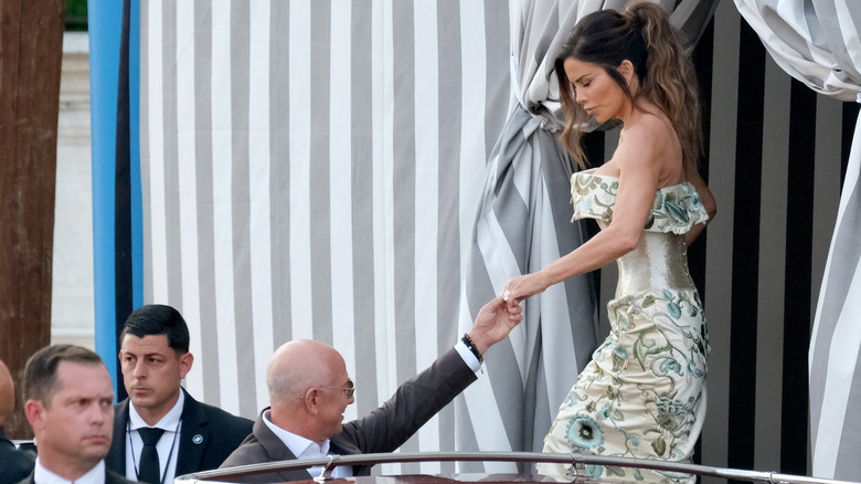 Lauren Sánchez wearing a gown in Venice, Italy, while Jeff Bezos gives her a hand