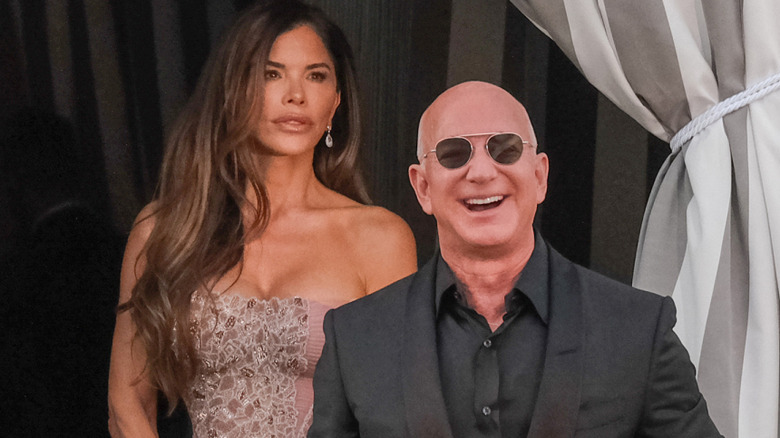 Lauren Sánchez and Jeff Bezos smiling while being photographed during their wedding weekend