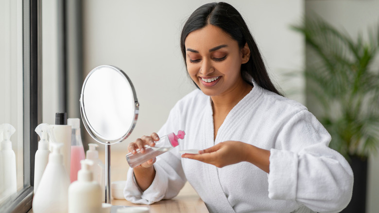 Woman in a robe holding a bottle