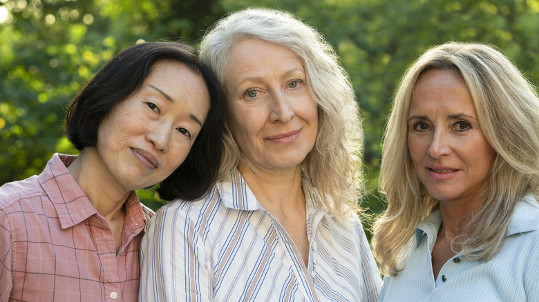 An older woman with black hair, and older women with white-blond hair, and an older woman with warm-blond hair and lowlights
