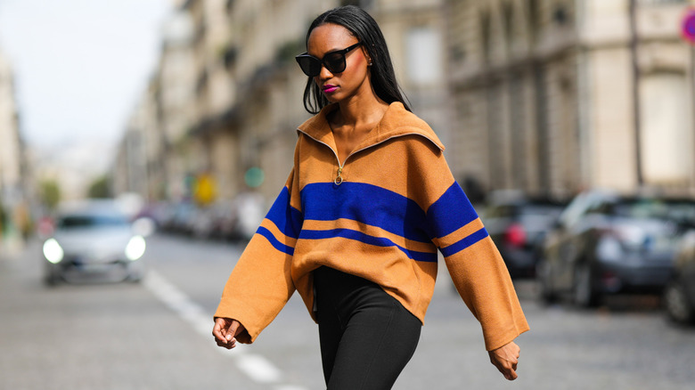 A woman wearing black leggings as part of her street-style oufit