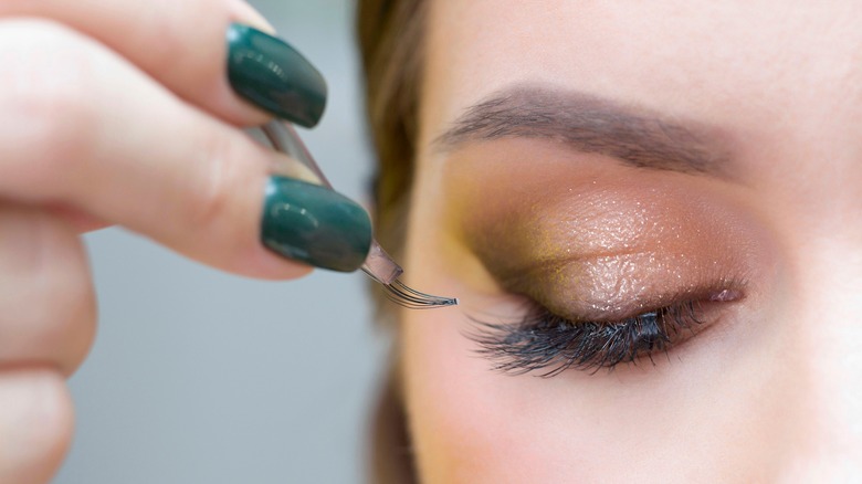 person putting on false lashes