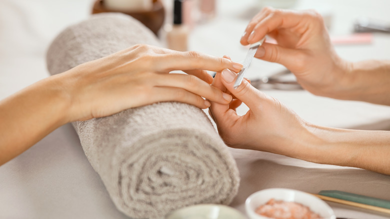 Close up of nails being shaped with a file
