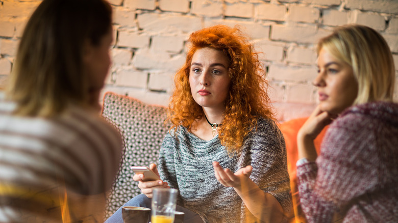 Three women talking over drinks