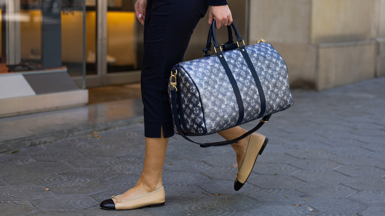 A woman wearing ballet flats with dark-blue capris