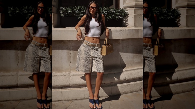 A person wearing snakeskin jorts with flip flops