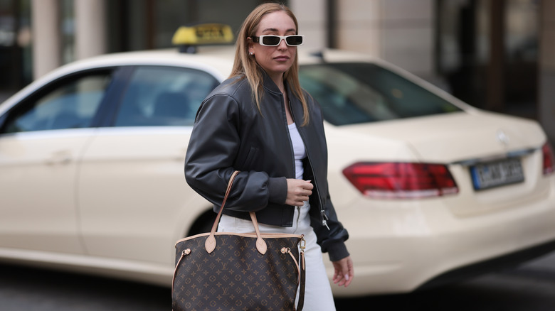 Sonia Lyson carrying a big Louis Vuitton purse on the street