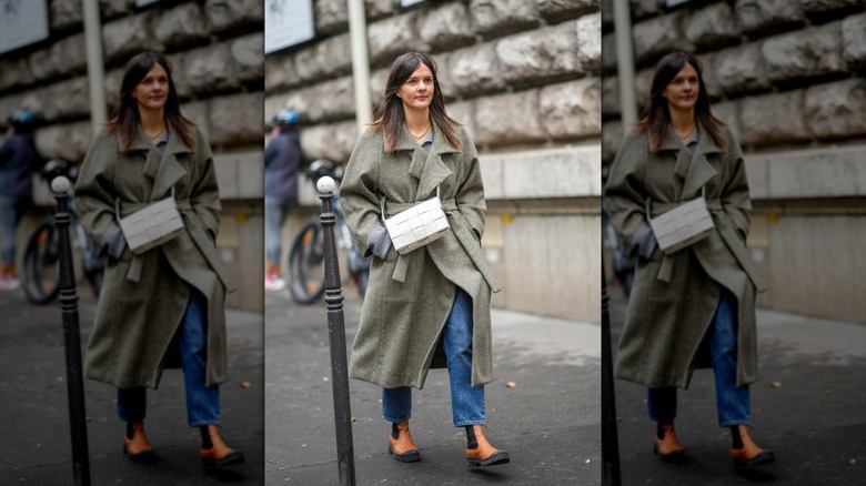 A woman walking with straight jeans and orange Chelsea boots