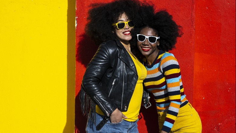 Two women standing in front of colorful building