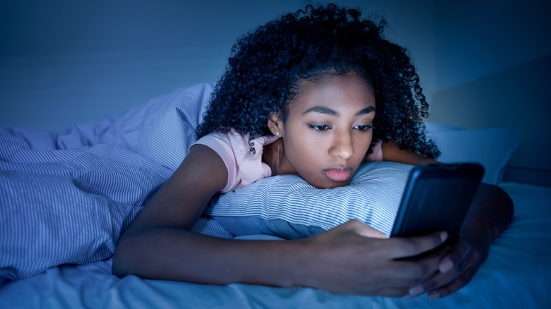 Woman texting in bed