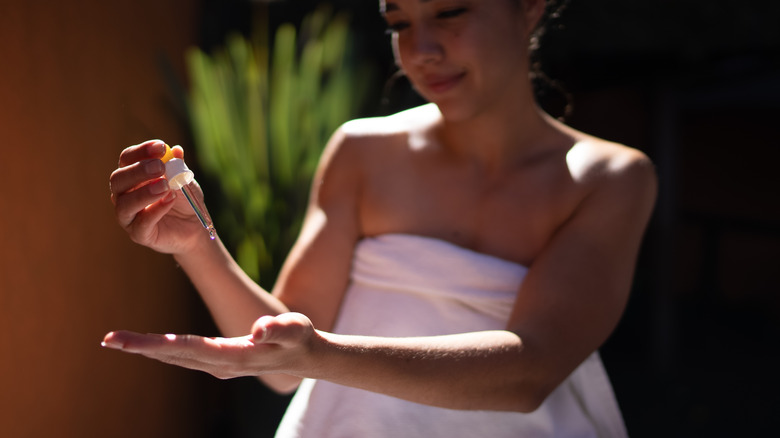 Woman holding essential oil dropper