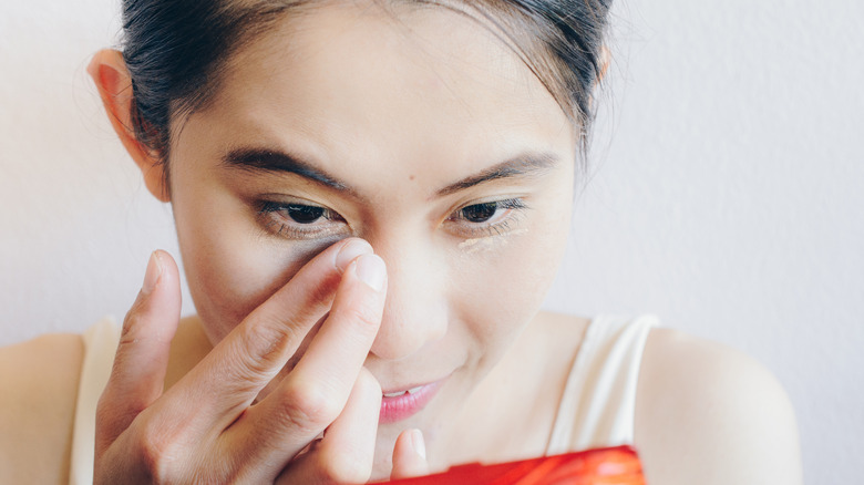 woman applying under eye concealer