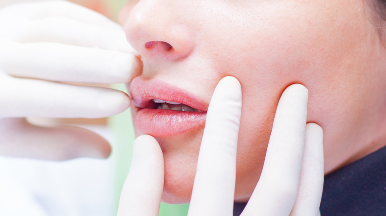 doctor touching woman's lips 