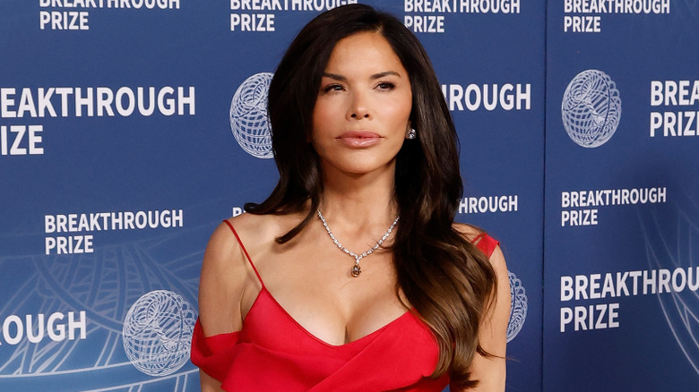 Lauren Sánchez wearing a red dress and posing on the red carpet