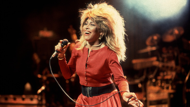 Tina Turner on stage in 1987 performing in a red dress