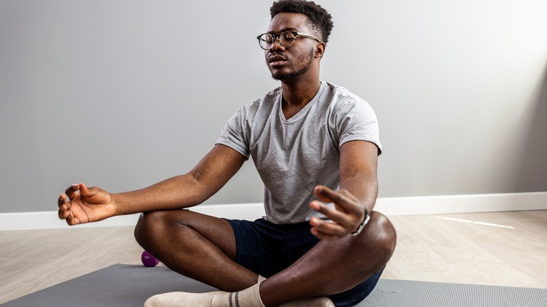 Man meditating on floor