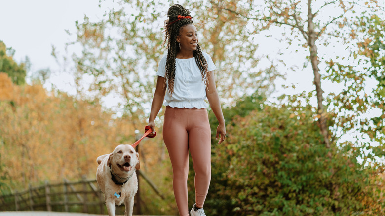 Woman walking dog outside