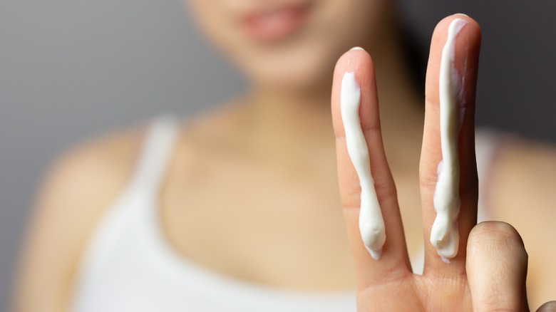 woman holding with sunscreen fingers