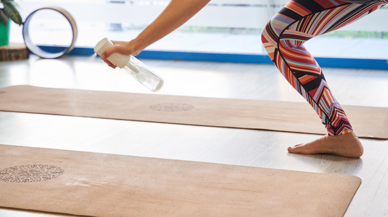 woman spraying yoga mat
