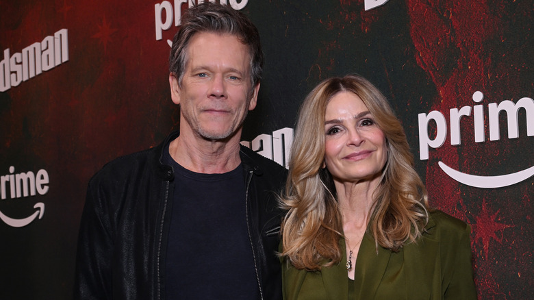 Kevin Bacon and Kyra Sedgwick walk arm in arm down a red carpet