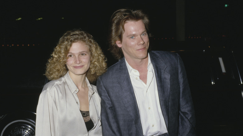 Kyra Sedgwick and Kevin Bacon walking side by side in 1988