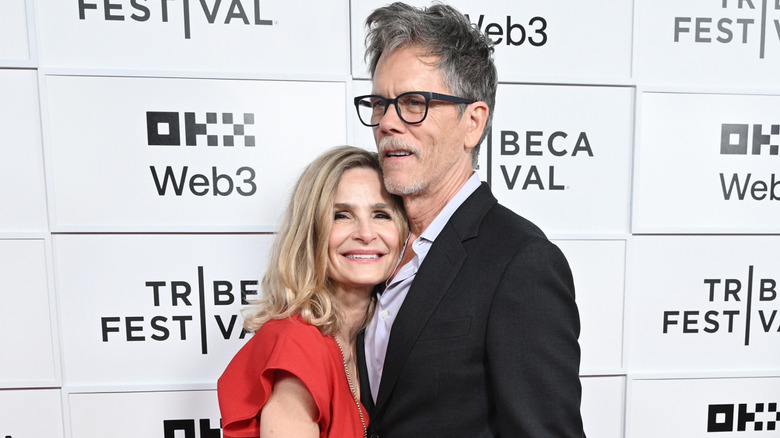 Kyra Sedgwick leans against her husband Kevin Bacon as the two are photographed on the red carpet