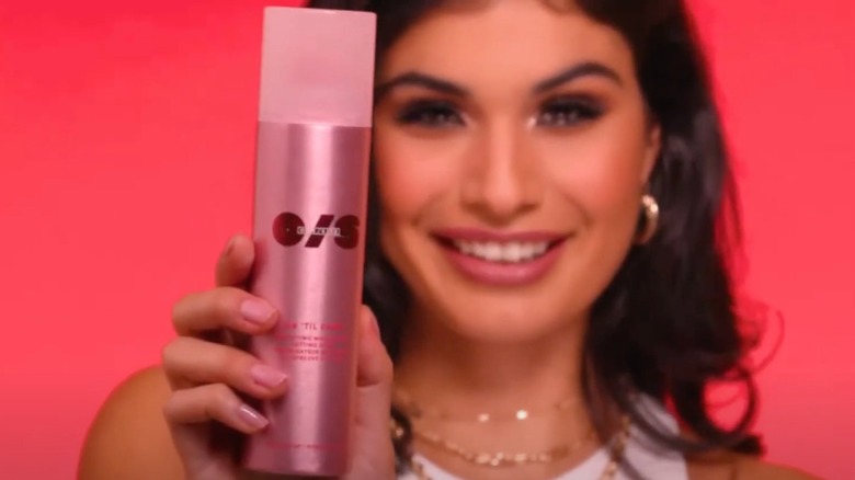 Model spraying One/Size setting spray onto face