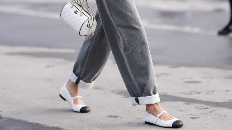 Woman walking in cuffed jeans with Chanel ballet flats