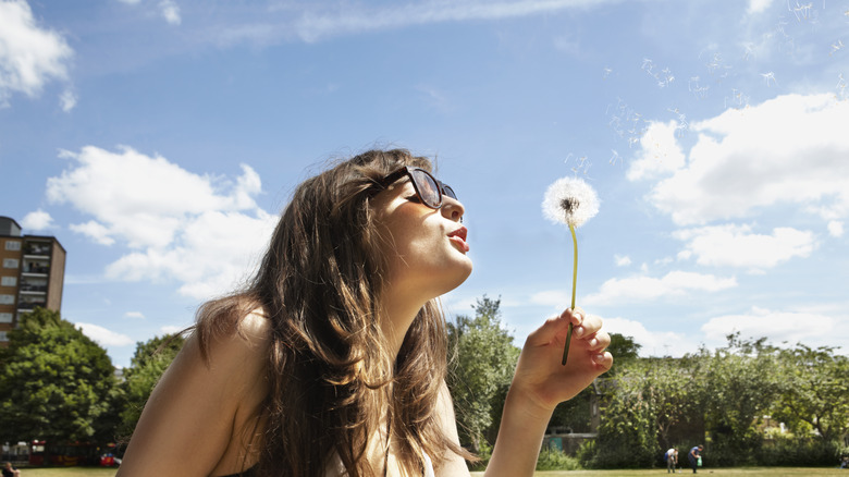 Girl blowing dandelion
