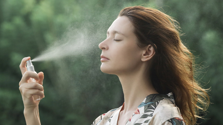 woman spraying mist on face