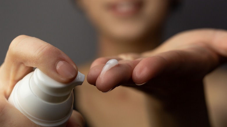 woman putting retinoid on fingertips
