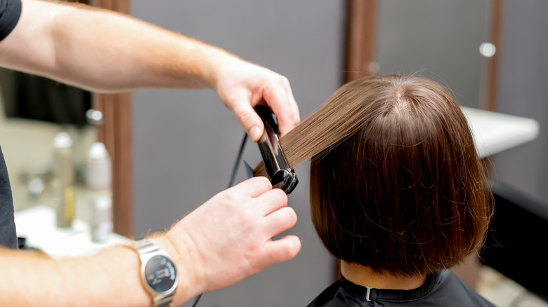 person getting her hair straighten