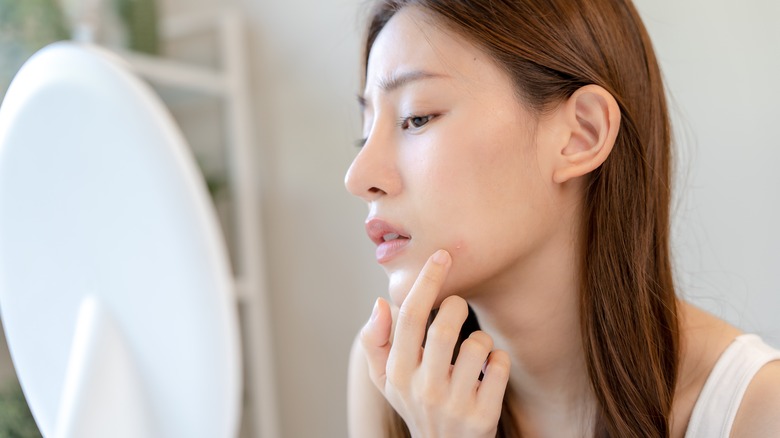 woman noticing a pimple