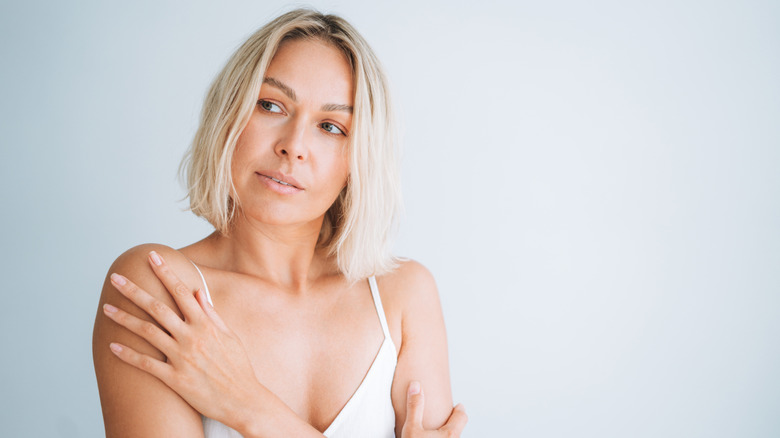 A woman holding her shoulders