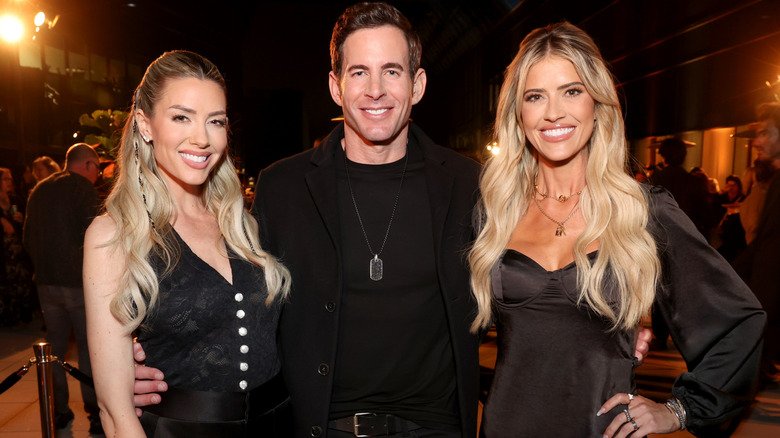 Tarek El Moussa posing between Heather Rae and Christina