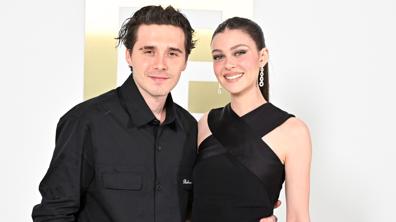Brooklyn Beckham and Nicola Peltz posing together at the Balmain Womenswear Spring-Summer 2025 show