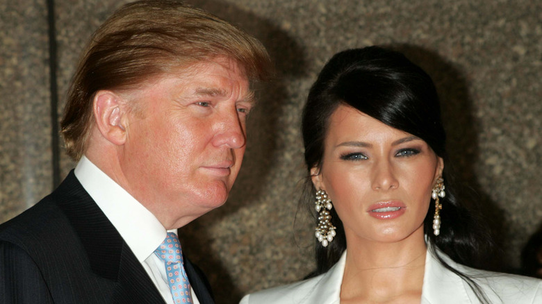 Donald Trump and Melania Trump with black hair and a side part