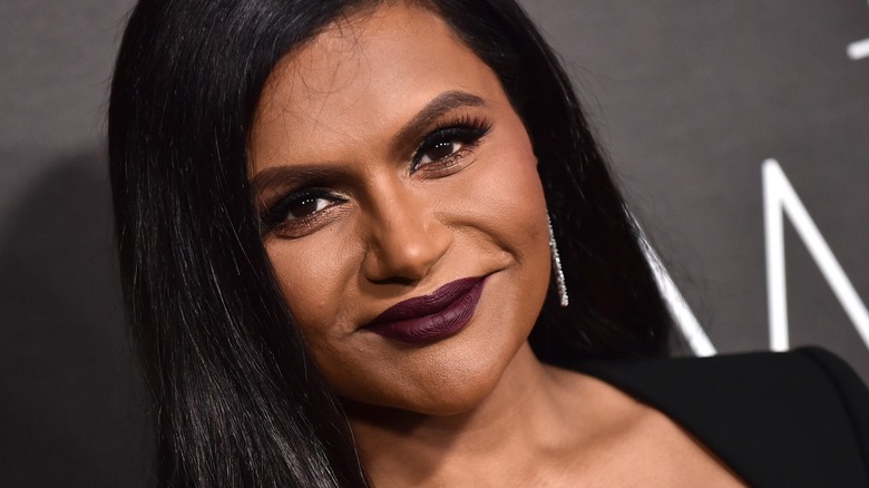 Mindy Kaling wearing black with deep-plum lips