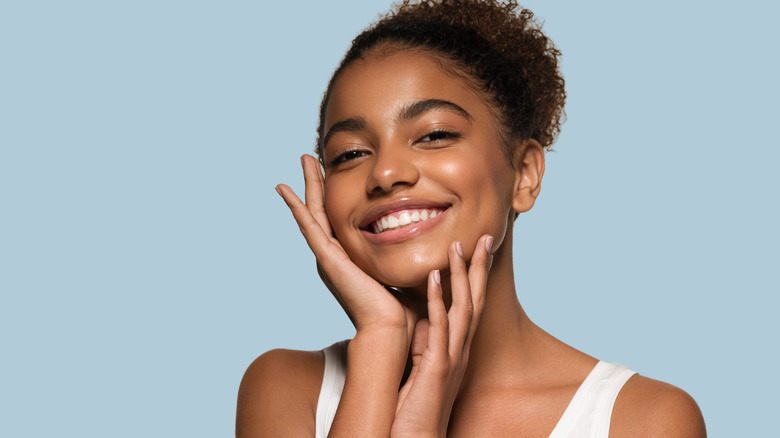 brown skinned girl with glowing skin smiling