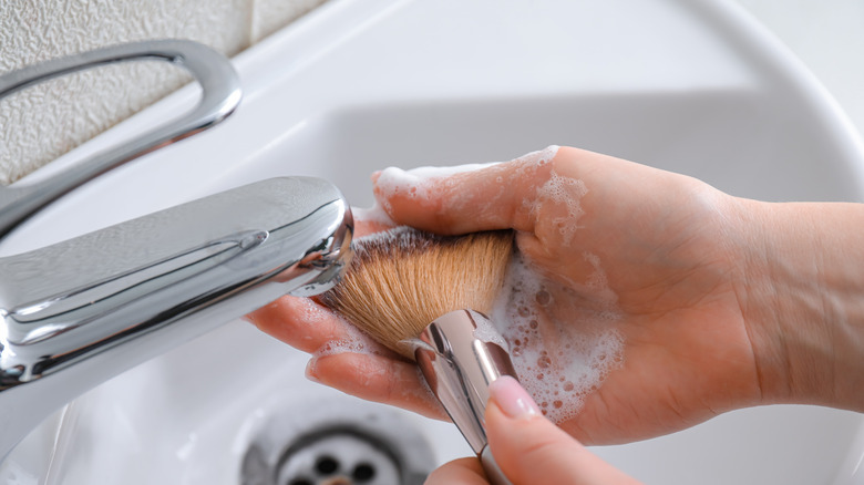 cleaning makeup brush in sink
