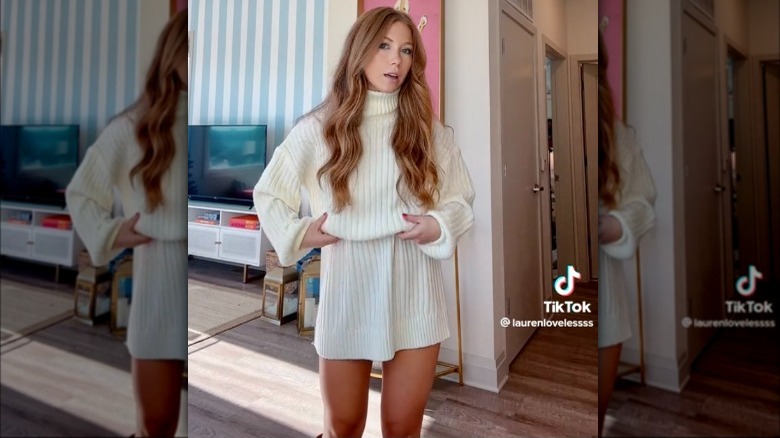 Woman tucking sweater dress